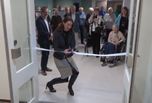 De wethouder knipt het lint door om Schouwenhove te heropenen